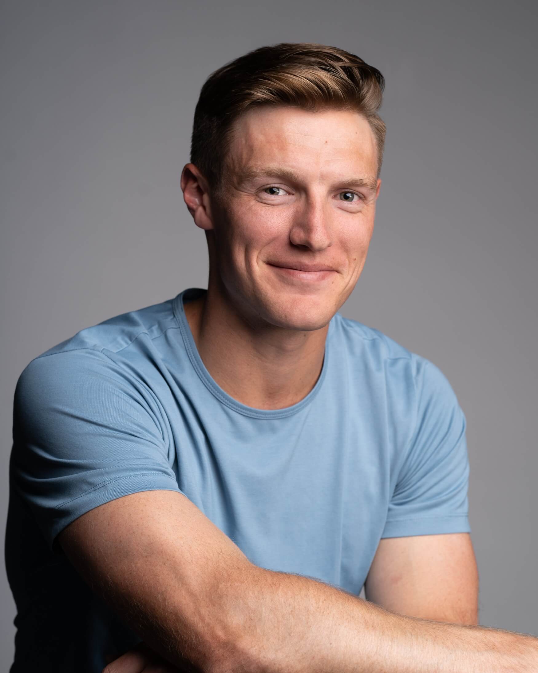 acting headshot photography example in studio with light blue shirt