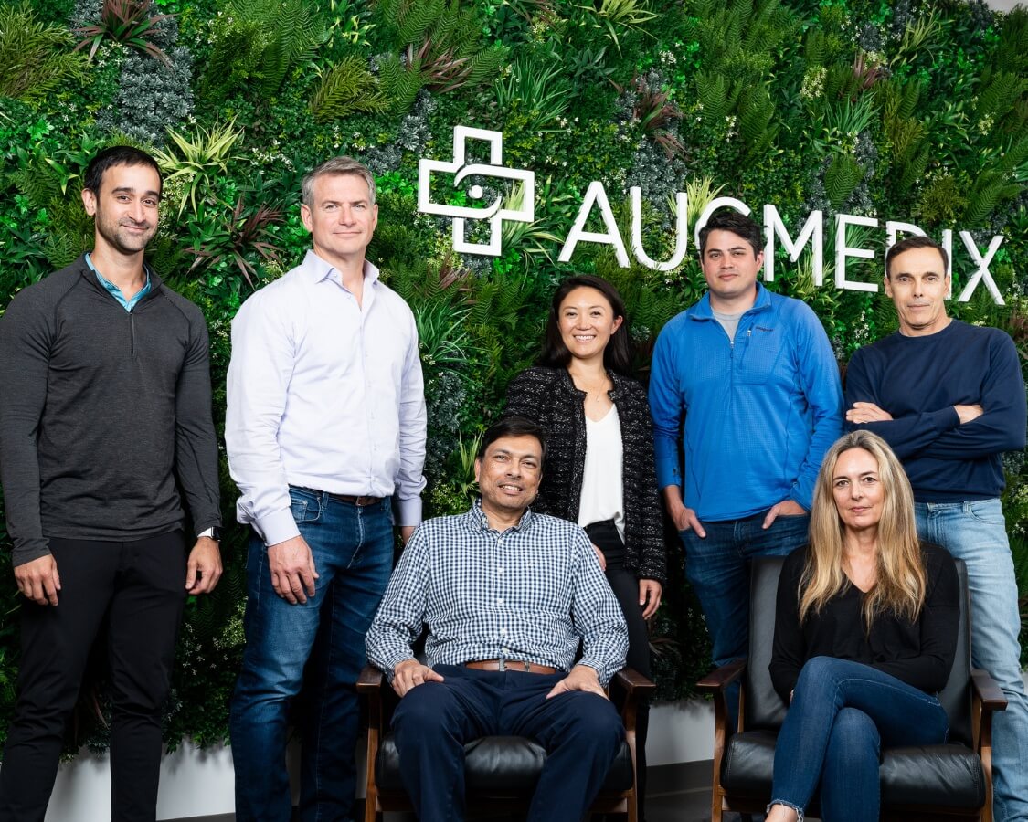 startup executive team photo with logo in background